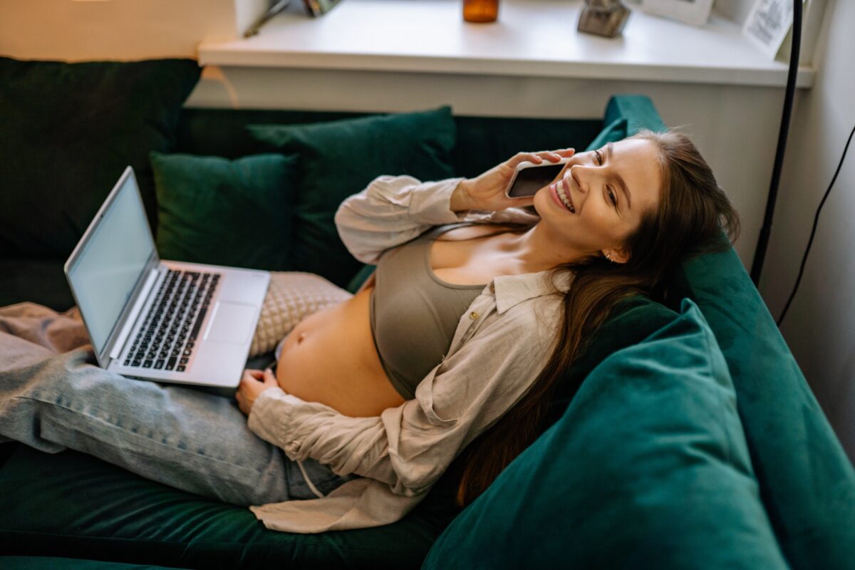 Kobieta w ciąży z telefonem i laptopem / Źródło: Pexels